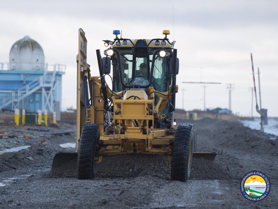 A man drives a road grader in Kotzebue. Image courtesy of Alaska Department of Transportation & Public Facilities