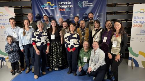 A large group smiles in front of a banner that says "UArctic Congress 2026"